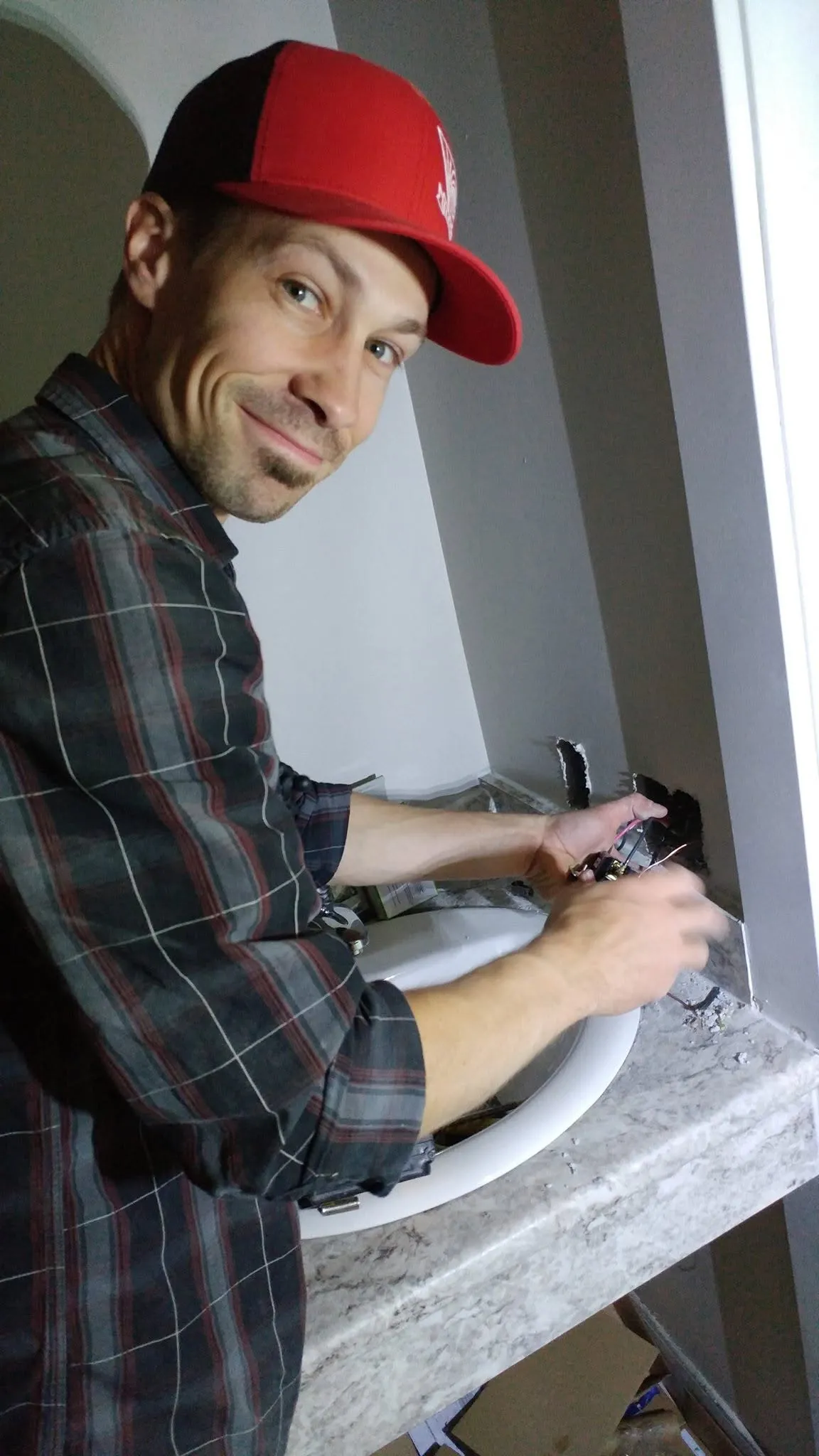 Gaetan LePage wiring a kitchen receptacle during a renovation