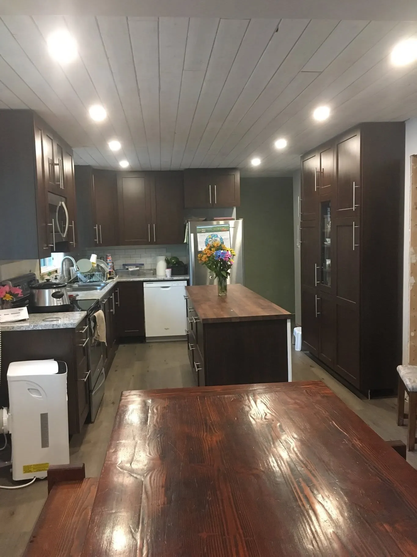 Renovated kitchen with pot lights in a wood ceiling
