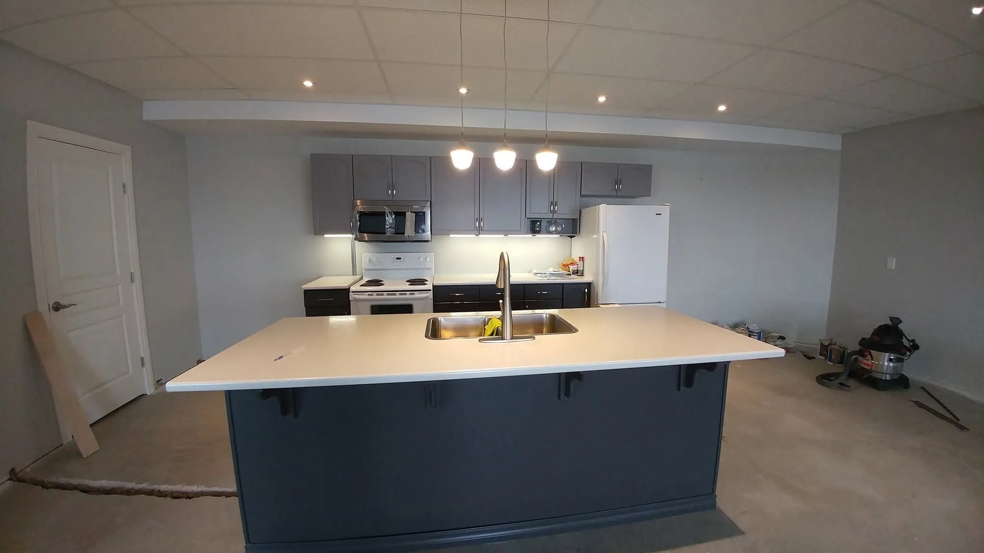 Kitchen island and lighting in a new build before flooring