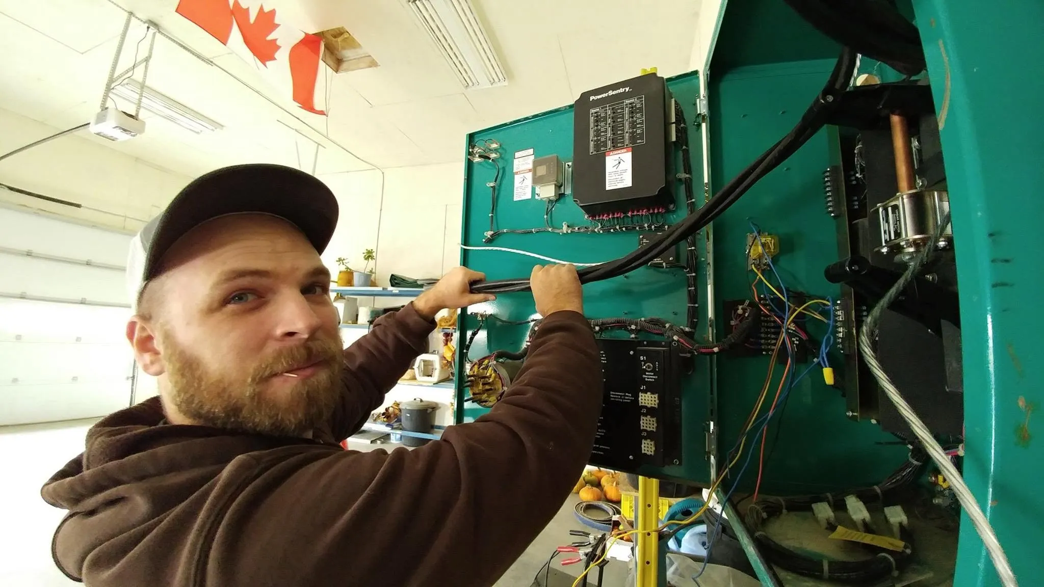 Electrician troubleshooting wiring inside an equipment panel